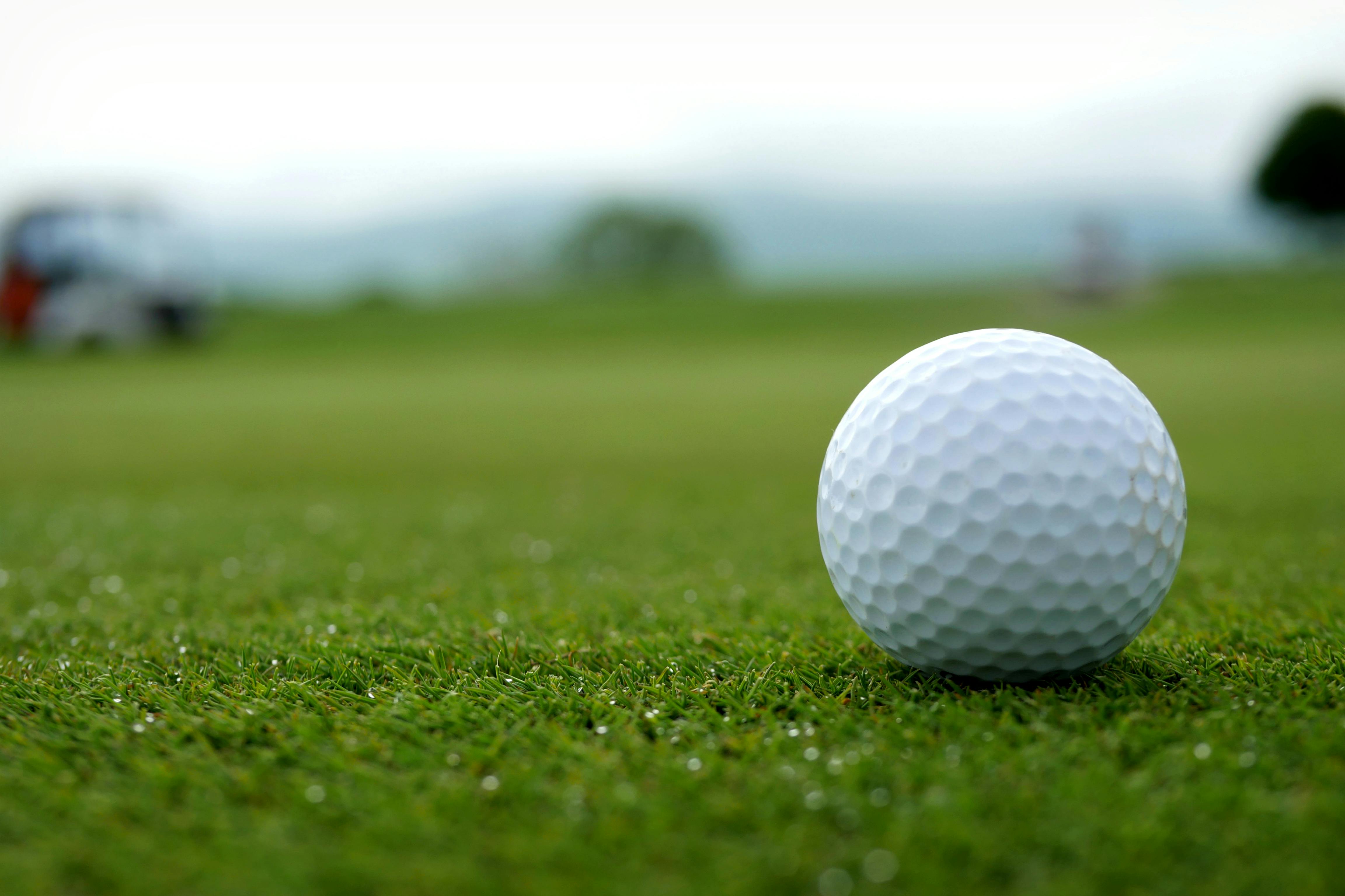 Image of golf ball on tee on grass.
